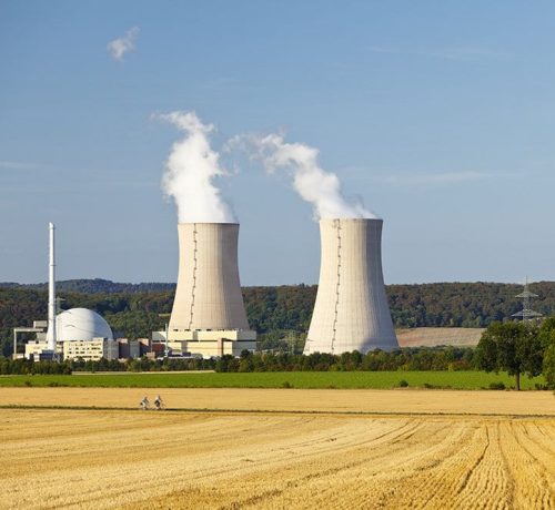 A nuclear power station with hill landscape and blue sky.